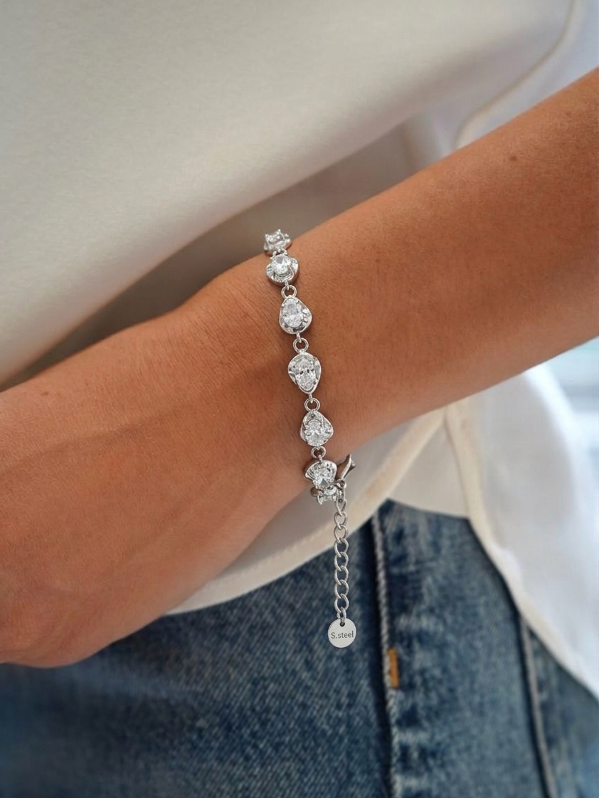 Silver bracelet with clear stones on a wrist against a white background