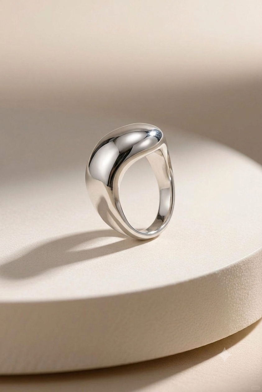 Silver ring with a modern design on a light beige background