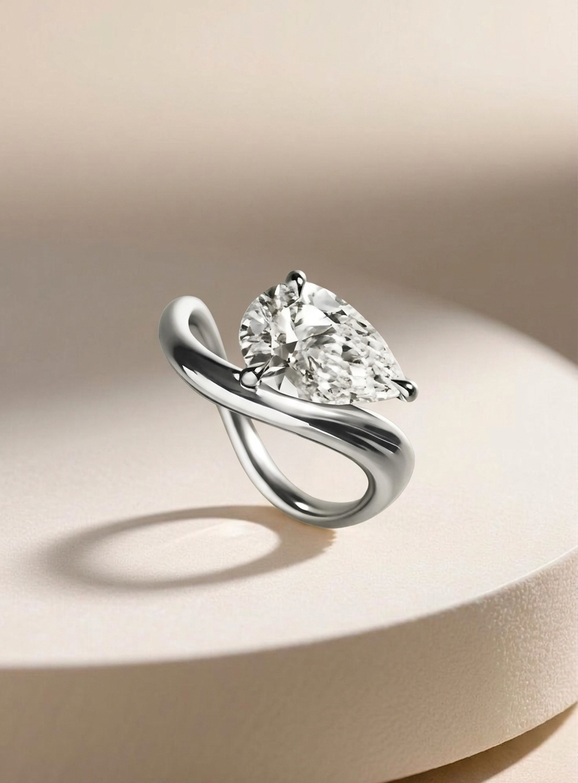 Silver ring with a pear-shaped diamond on a beige background