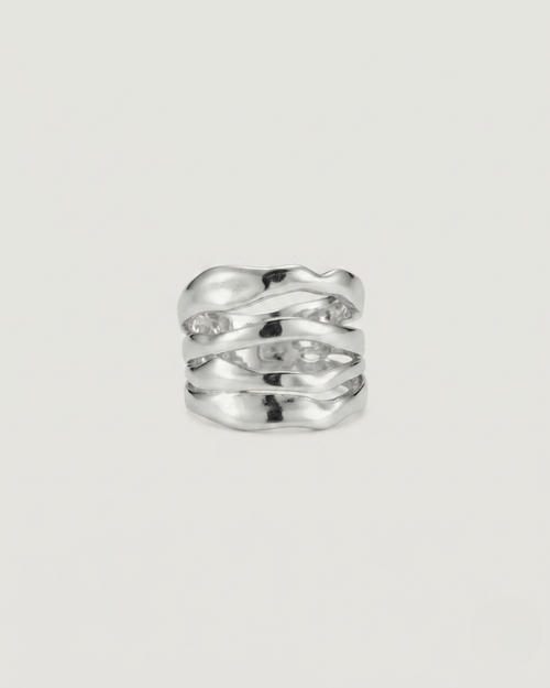 A silver-toned wavy band ring with a textured, organic sculpted design, photographed on a clean, light off-white background.