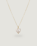 A delicate gold chain necklace featuring a small, irregularly shaped white baroque pearl pendant, displayed against a solid light gray background.