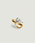 A yellow gold ring featuring a pear-cut clear gemstone in a curved, intertwined band setting, presented on a light gray background.