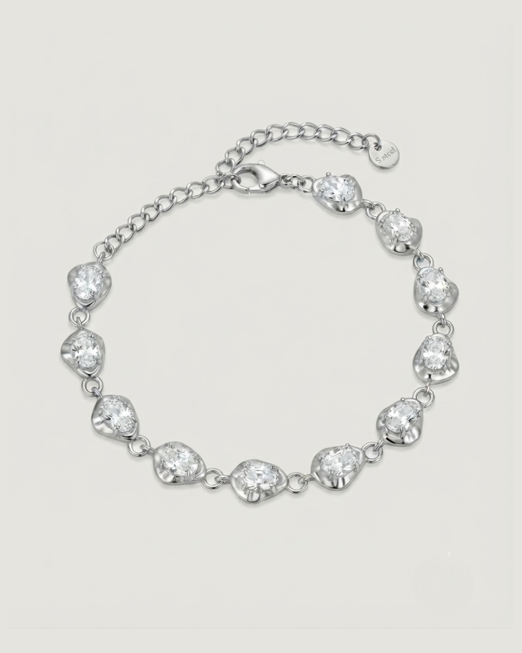 A silver chain bracelet featuring irregular, organic-shaped clear gemstones set in polished silver-toned metal, displayed on a light beige background.