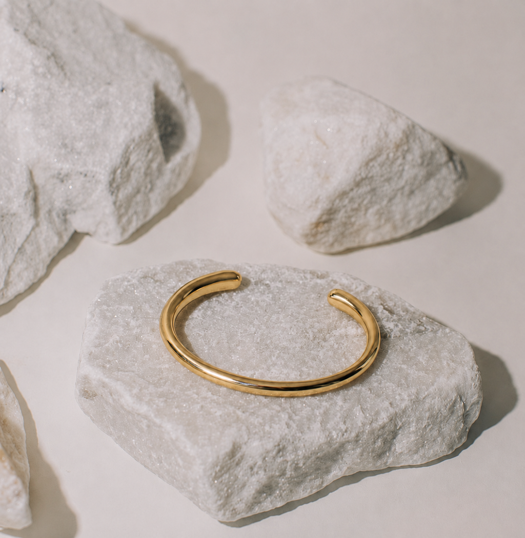 gold metal bangle on stone