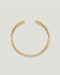 A minimalist gold-toned metal hoop earring with an open, curved design, displayed on a clean light gray background.