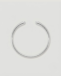 A minimalist silver-toned metal cuff bracelet, shown on a neutral light gray background.