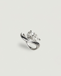 A silver ring featuring a pear-cut clear gemstone in a curved, intertwined band setting, presented on a light gray background.